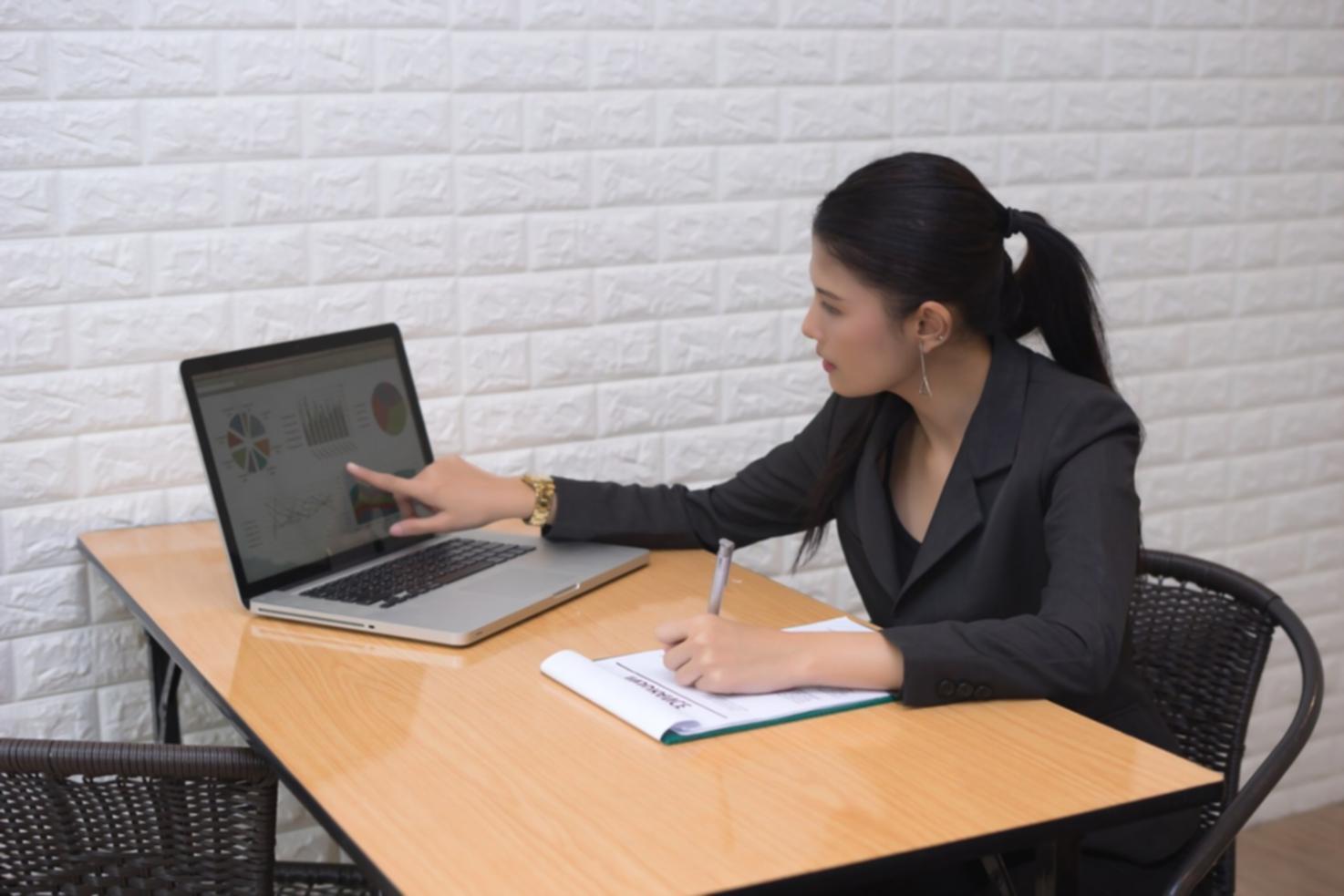 Étudiant analysant des données financières sur plusieurs écrans